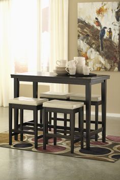 a dining room table and chairs with a rug