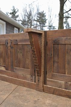 a close up of a wooden gate with a house in the background