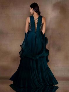 Dark green corset gown featuring a hand embellished part-sheer bodice & a flowy bottom with two gathered tiers. Paired with a metal buckled belt & an organza georgette combination dupatta.From Shloka Khialani's Winter Sun collection.DELIVERY TIMEPlease allow 6-8 weeks for your outfit to arrive.FABRIC DETAILSGeorgette, Organza, CrepeProfessional cleaning only. Reception Gown With Ruffles In Georgette, Fitted Georgette Gown With Ruffles, Party Gown With Ruffles In Georgette, Festive Ruffled Georgette Gown, Festive Reception Dress With Sheer Sleeves, Anarkali Floor-length Dress With Ruffles, Wedding Maxi Dress With Ruffles In Georgette, Floor-length Dresses With Sheer Sleeves For Reception, Floor-length Georgette Gown For Gala