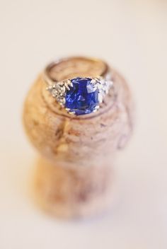 a ring with a blue stone in it sitting on top of a cork