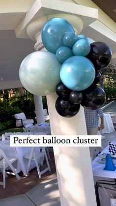 balloons are attached to the top of a column at an outdoor event with white tables and chairs