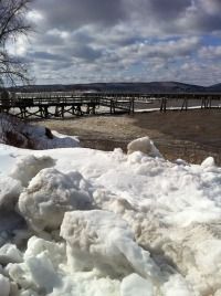 snow piled up on the ground in front of a bridge