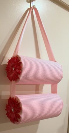 a pink and red item hanging from the ceiling next to a white object with two flowers on it