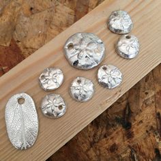 several metal buttons sitting on top of a piece of wood next to a wooden board