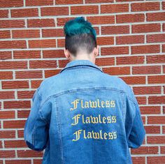 a man with green hair wearing a jean jacket that says fearless, fearless and fabulous