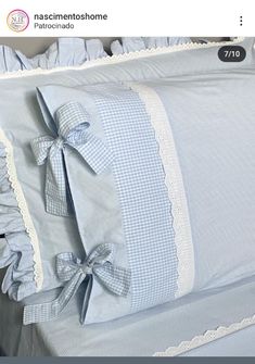 a blue and white bed with ruffles on the pillow covers, and a bow at the bottom