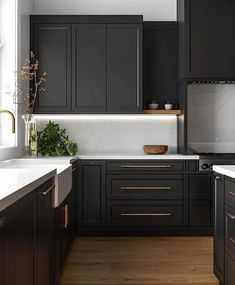 a kitchen with black cabinets and white counter tops