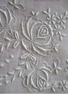 an embroidered fabric with flowers and leaves on it