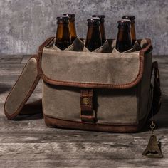 six beer bottles in a canvas bag on a wooden table