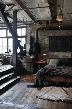 an industrial bedroom with exposed brick walls and wooden floors