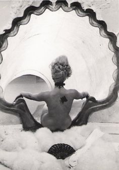 a naked woman sitting in front of a mirror