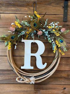 a wreath with the letter r hanging on a wall next to a wooden sign that says,