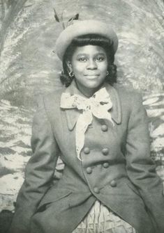 an old black and white photo of a woman wearing a hat