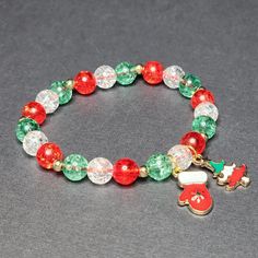 a red and green beaded bracelet with a santa clause ornament on it