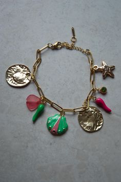 Golden charm bracelet featuring pink and green charms  This style of bracelet is perfect for jazzing up any outfit! Beach Charm Bracelet, Green Charms, Gold Charm Bracelet, Charm Necklaces, Coin Jewelry, Gold Charm, Charm Bracelets, Horn, Halloween Shopping