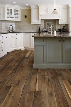 a kitchen with wooden floors and white cabinets