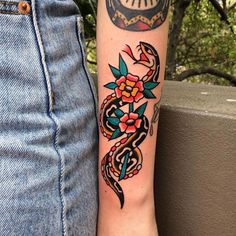 a woman's arm with a tattoo on it and a clock in the background