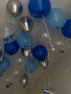 blue and silver balloons are hanging from the ceiling