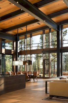 a large open living room with lots of windows and wood flooring on the walls