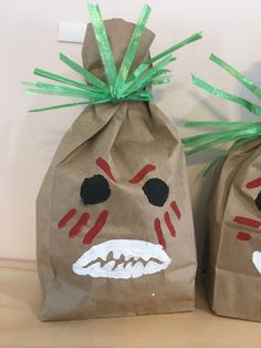 two brown paper bags with faces painted on them