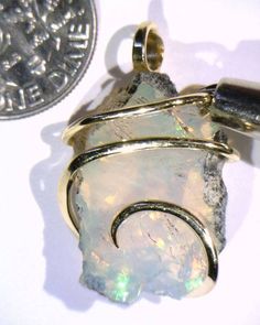 14.71ct African Crystal Opal in 14kt Gold Art Wire Wrap Pendant 14.71 carats total weight DON'T MISS OUR OTHER AUCTIONS & EBAY STORE! Total weight 14.71 carats including wrap Size 26 mm by 17 mm by 8 mm including wrap Up for sale is a beautiful natural African opal artfully wrapped in a 14kt gold tension wire wrap. This stunning piece is beyond compare and the pictures hardly do it justice. The glowing stone is radiant with flashes of green, yellow, and red fire that consume the entire piece jumping out at the eye with the slightest movement. To top it off are the swirling waves of glowing 14kt gold that securely grasp the stone and set it off to perfection. The perfect piece for any collection! Wire wrapping or Wire sculpture is one of the oldest techniques for making jewelry by hand. But Wire Wrapped Jewelry Pendant, Set It Off, Artisan Jewelry Necklaces, Art Wire, Wire Wrap Pendant, Wire Jewelry Designs, Crystal Opal, Handcrafted Artisan Jewelry, Wire Sculpture