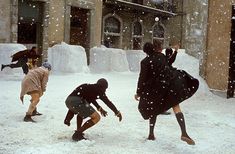 three people playing in the snow with each other