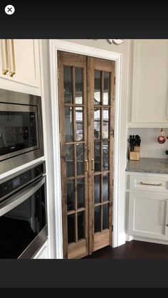 a kitchen with an oven, microwave and double doors that lead to the dining room