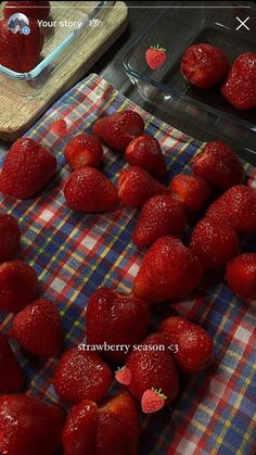 strawberries are arranged on a plaid table cloth