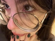 a close up of a person wearing glasses and holding their hand to her face with the eyeglasses on