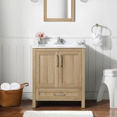 a bathroom with a sink, mirror and toilet paper roll on the floor next to it