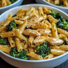 two bowls filled with pasta and broccoli on top of a wooden table,