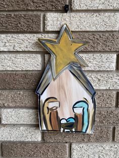 a nativity scene painted on the side of a brick wall with a star above it