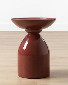 a brown vase sitting on top of a wooden floor