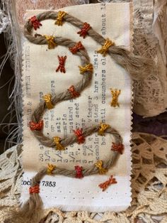 a piece of fabric with orange and yellow flowers on it sitting on top of lace