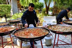 a man is preparing food on large grills