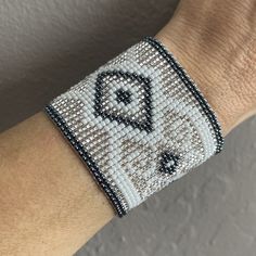 a close up of a person's arm wearing a beaded bracelet with an elephant on it