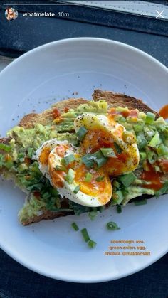 an egg and avocado toast on a white plate