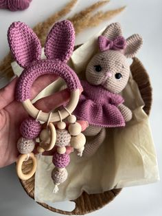 a hand holding a crocheted bunny keychain with a wooden bead