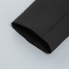 a black piece of cloth folded on top of a white surface