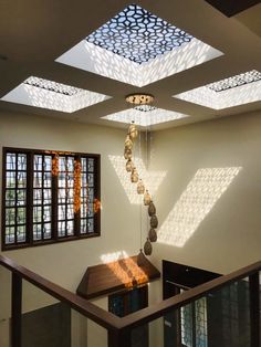 the sun shines through some windows in an empty room with wood flooring and decorative lighting