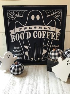 some black and white pumpkins sitting on a table next to a sign that says boo'd coffee