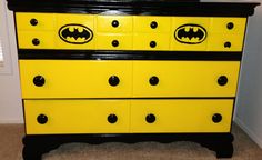 a yellow and black dresser with batman decals on it