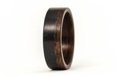 a wooden ring with black and brown wood inlays on the inside, against a white background