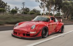 a red sports car driving down the road