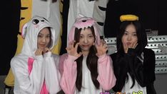 three girls in costumes standing next to each other with their hands on their faces and fingers up