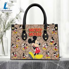 Mickey Mouse Brown Pattern Premium Leather Handbag It’s a practical accessory for fashion-conscious individuals on the go and makes an excellent gift choice for special occasions. The bag is crafted with care and attention to detail, made of high-quality PU leather with a soft microfiber layer that protects your belongings. It features two zippered pockets, one flat pocket, and one detachable pocket, making it ideal for organizing your essentials. The bag is spacious enough to hold everyday item Leather Bag Tag, Mickey Cartoon, Custom Leather Bag, Mickey Cartoons, Small Hand Bags, One Piece Cartoon, Bags And Purses, Brown Pattern, Personalize Bag