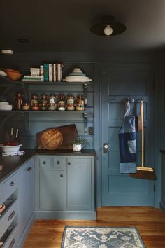 a kitchen with blue cabinets and wooden flooring is pictured in this image from the front door