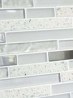 a white tile backsplash with silver accents