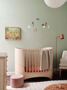 a baby's room with a crib, chair and ottoman