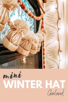 a mirror that has some knitted hats hanging from it's frame and the words, mini winter hat garland